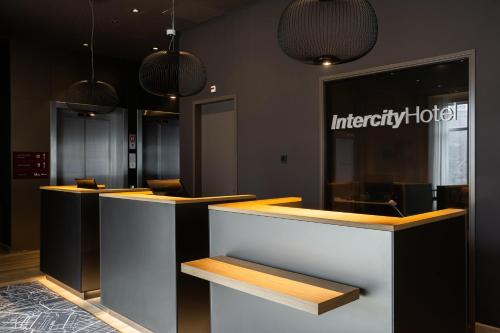 a lobby of a hotel with two counters and lights at IntercityHotel Leiden in Leiden