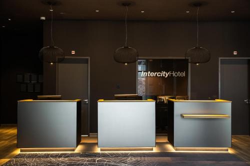a lobby with two tables and aiety hotel sign at IntercityHotel Leiden in Leiden