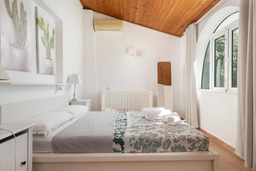 a white bedroom with a bed and a window at 4 bedrooms house with private pool and wifi at Alcudia in Alcudia