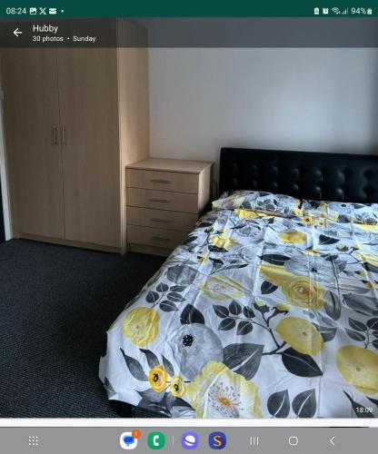 1 dormitorio con 1 cama con colcha de flores en detached house neat, en Wellingborough