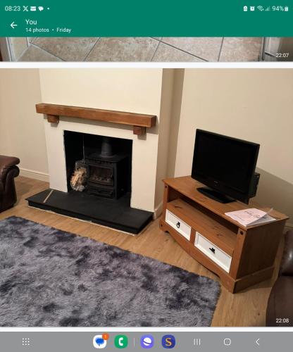 a living room with a fireplace and a tv at detached house neat in Wellingborough