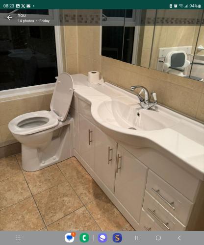 a bathroom with a toilet and a sink and a mirror at detached house neat in Wellingborough