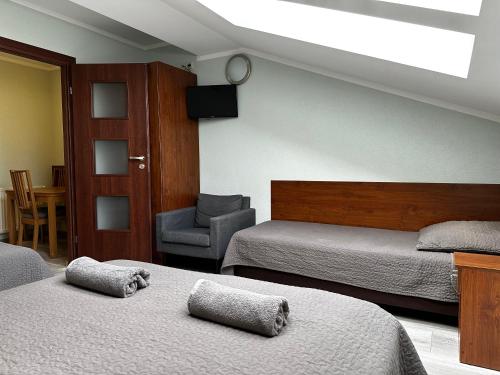 sypialnia z 2 łóżkami i krzesłem w obiekcie Apartament Serwis w Krakowie