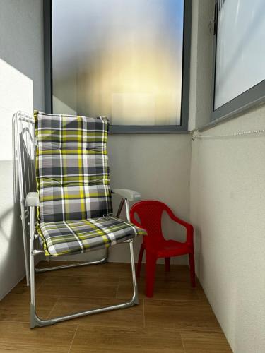 a chair and a red chair in a room at Apartmani Lotus Vrdnik in Vrdnik
