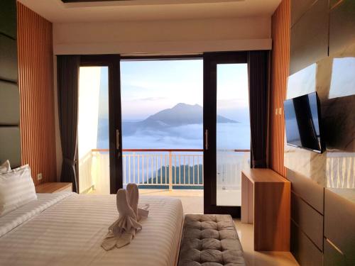 a bedroom with a bed and a balcony with a view at Batur view Homestay - Loft in Kintamani