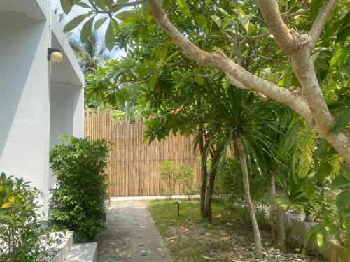 a garden with trees and a fence at Phangan Hometown Resort - Adults Only in Baan Tai