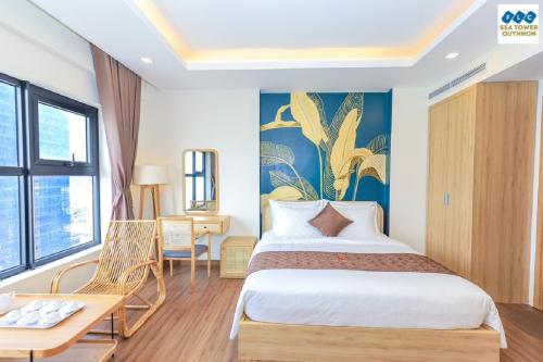 um quarto de hotel com uma cama grande e uma mesa em FLC Sea Tower - Seaview Apartment em Quy Nhon