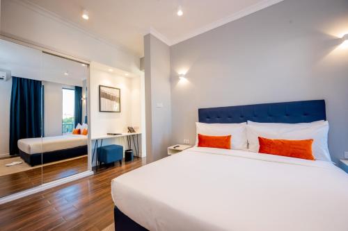 a bedroom with a large bed with orange pillows at Urban by CityBlue Hotel, Dar es Salaam in Dar es Salaam