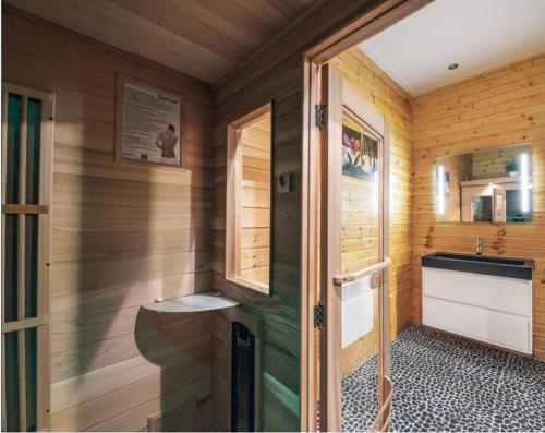 a small bathroom with wooden walls and a sink at Villa Elsa in Durbuy