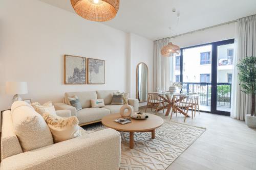 a living room with a couch and a table at HiGuests - Luxurious Boho Beach 2BR Apartment in La Mer in Dubai