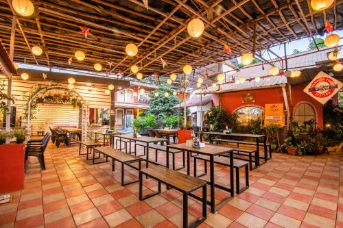 羅納瓦拉的住宿－Flora Ecostay Resort and Spa Lonavala，一间设有木桌和长凳的餐厅
