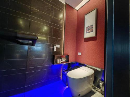 a bathroom with a toilet and a shower with blue lighting at Mehood Elegant Hotel Xi'an Big Wild Goose Pagoda Tang Dynasty City in Xi'an