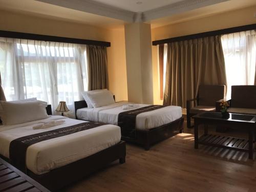 una habitación de hotel con 2 camas y un piano en Punakha Residency en Punākha