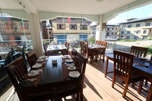 una sala da pranzo con tavolo e sedie sul balcone di Punakha Residency a Punakha