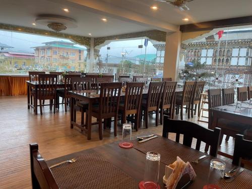 un comedor con mesas de madera y sillas en un restaurante en Punakha Residency en Punākha