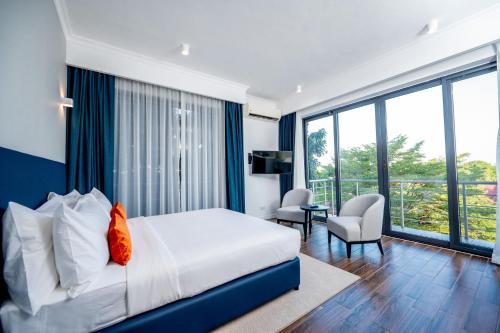 a hotel room with a bed and a balcony at Urban by CityBlue Hotel, Dar es Salaam in Dar es Salaam
