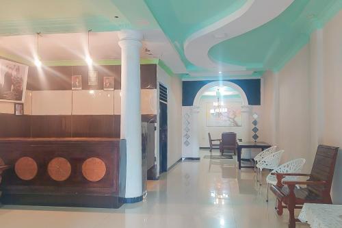 a dining room with a table and chairs and a pillar at Summarend Hotel RedPartner in Hiliotaluwa