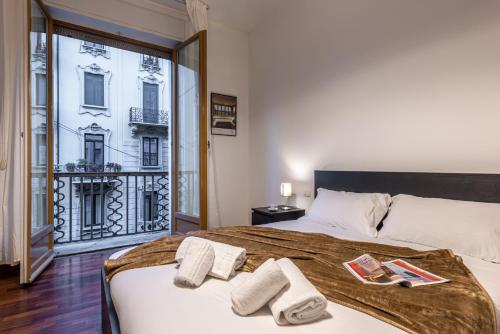 1 dormitorio con 1 cama grande y toallas. en Cortivo House - Magenta 81, en Milán