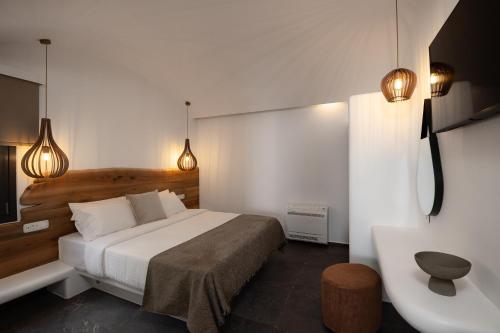 um quarto com uma cama, um lavatório e luzes em Secret Path Luxury Villas em Imerovigli