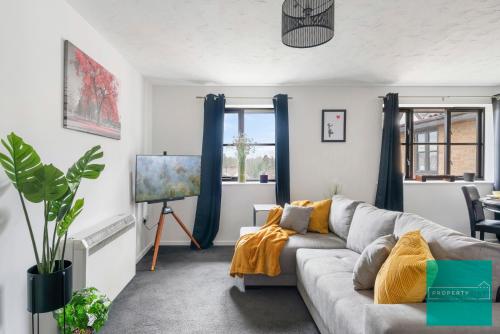 a living room with a gray couch and blue curtains at Luxury 2 bed, 2 bath apartment in North London in London