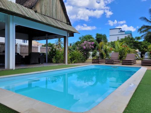 a swimming pool in the backyard of a house at Villa Kayana in Flic-en-Flac