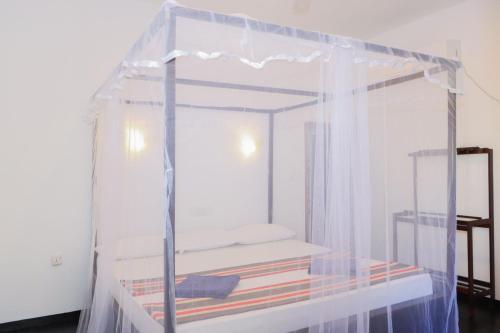 a bedroom with a canopy bed with books at Lucky Bay in Arugam Bay