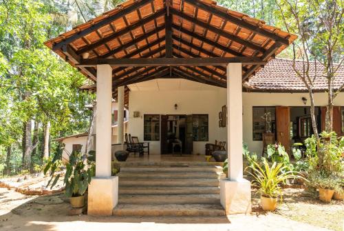 a house with a wooden pergola over the stairs at Captain's Bungalow, Kandy in Arawwawala