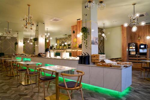 a restaurant with tables and a counter with green lights at ApartPark Baltic Home in Świnoujście