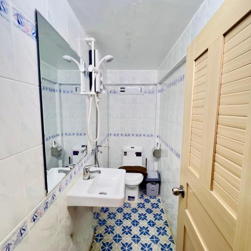 a bathroom with a sink and a toilet and a mirror at Sun Chakra Boutique Hotel - 50m to Museum & Royal Palace & Walking street in Phnom Penh