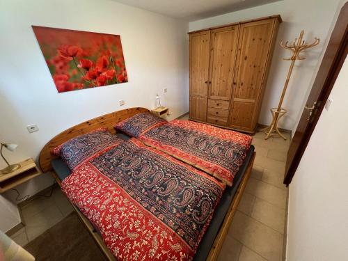 a bedroom with a bed and a painting on the wall at Ferienwohnung Klausgraben in Bischofswiesen