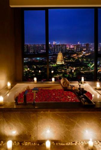 a bathroom with a bath tub with a view of a city at Mehood Elegant Hotel Xi'an Big Wild Goose Pagoda Tang Dynasty City in Xi'an