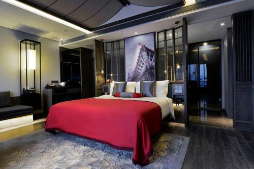 a bedroom with a large bed with a red blanket at Mehood Elegant Hotel Xi'an Big Wild Goose Pagoda Tang Dynasty City in Xi'an