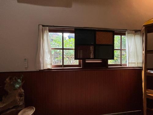 ein leeres Zimmer mit einem Fenster mit weißen Vorhängen in der Unterkunft Near Ubud, Batuan Homestay Own King Bed Big Room at Royen Balinese Family Guest House in Sukawati