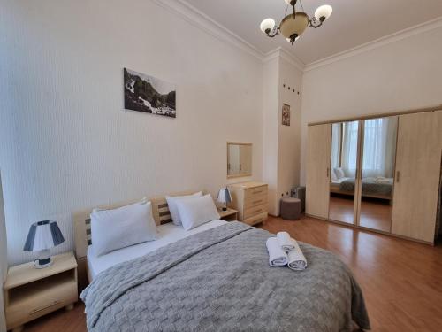 a bedroom with a bed with a pair of shoes on it at Malakan apartment in Baku