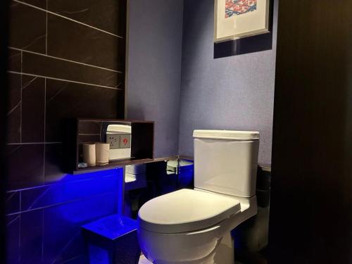 a bathroom with a white toilet in a blue room at Mehood Elegant Hotel Xi'an Big Wild Goose Pagoda Tang Dynasty City in Xi'an