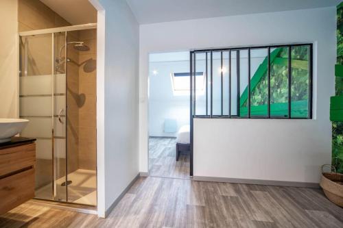 une salle de bain avec douche et porte vitrée dans l'établissement Le Loft Philibert, à Tournus