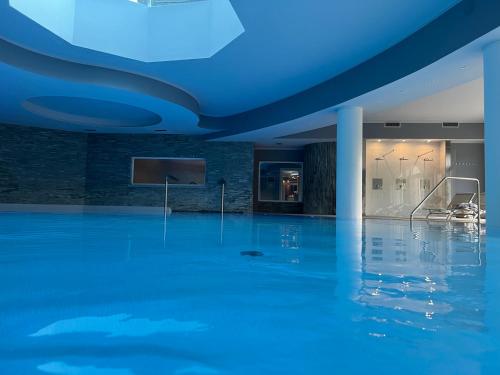a room with a blue ceiling and a television at Bes Hotel Terme a Palazzago in Palazzago