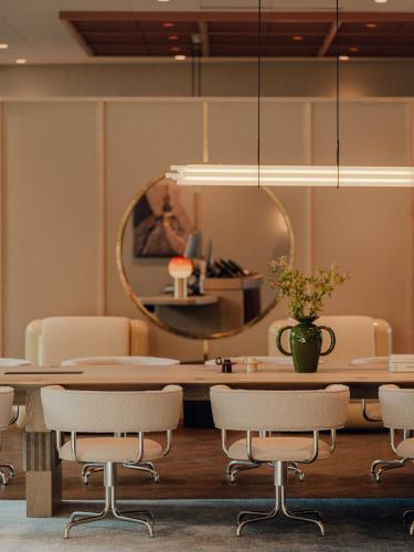 a dining room with a table and chairs and a mirror at PURO Hotel Poznań Stare Miasto in Poznań