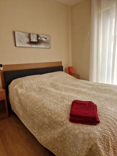 una camera da letto con un letto e un asciugamano rosso sopra di Calle Monteagudo a Torrevieja