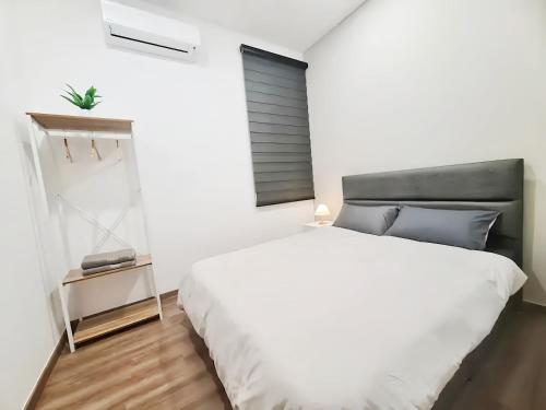 a bedroom with a large white bed and a window at The Cove Hillside Residence Ipoh in Ipoh