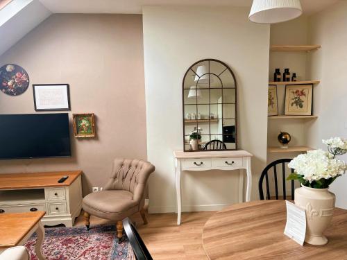 a living room with a television and a table and chairs at The Brick House - Appartement Renoir in La Roche-Guyon