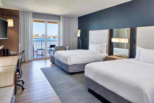 um quarto de hotel com duas camas e uma varanda em Courtyard by Marriott St. Petersburg Clearwater/Madeira Beach em St. Pete Beach