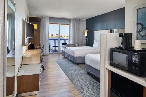 a hotel room with a bed and a television at Courtyard by Marriott St. Petersburg Clearwater/Madeira Beach in St Pete Beach
