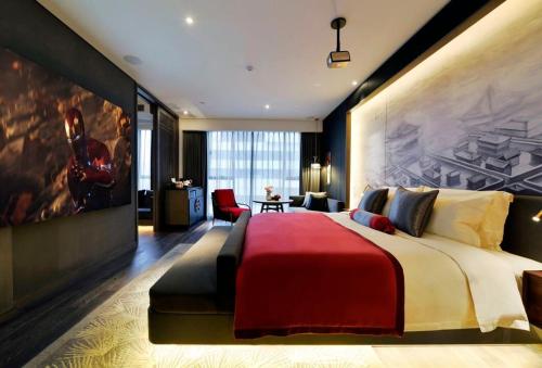 a bedroom with a large bed with a painting on the wall at Mehood Elegant Hotel Xi'an Big Wild Goose Pagoda Tang Dynasty City in Xi'an
