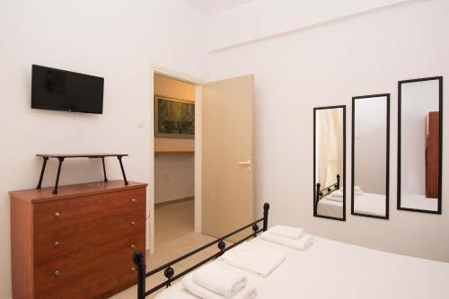 1 dormitorio con cama, tocador y espejo en Handakos Loft "by Checkin" en Heraclión
