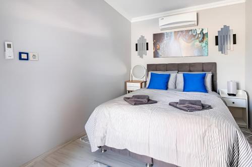 a white bedroom with a large bed with blue pillows at Villa Blue House Garden Hot Tub Konyaalti Antalya in Antalya