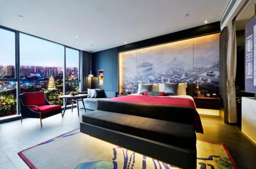a bedroom with a large bed and a large window at Mehood Elegant Hotel Xi'an Big Wild Goose Pagoda Tang Dynasty City in Xi'an