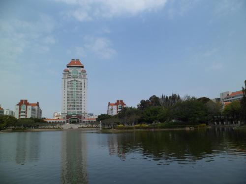 a building with a tower in the middle of a lake at City Hotel Xiamen-Free Welcome Fruits in Xiamen