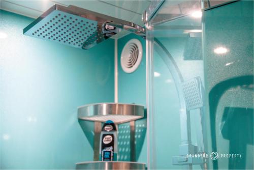 a shower in a bathroom with a blue wall at Stunning 1 Bed Garden Apartment - City Centre with Parking - The Gardenside Apartment in Bournemouth