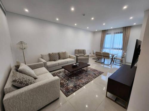 a living room with a couch and a table at Beachfront 2BHK apartment at Al Mouj in Seeb